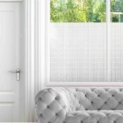 A simple all-over pattern with 2 chunky lines in a square adorns privacy film for windows in a living room.