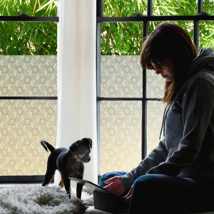 Privacy window film with a lacy floral pattern blocks passersby from a bedroom window.